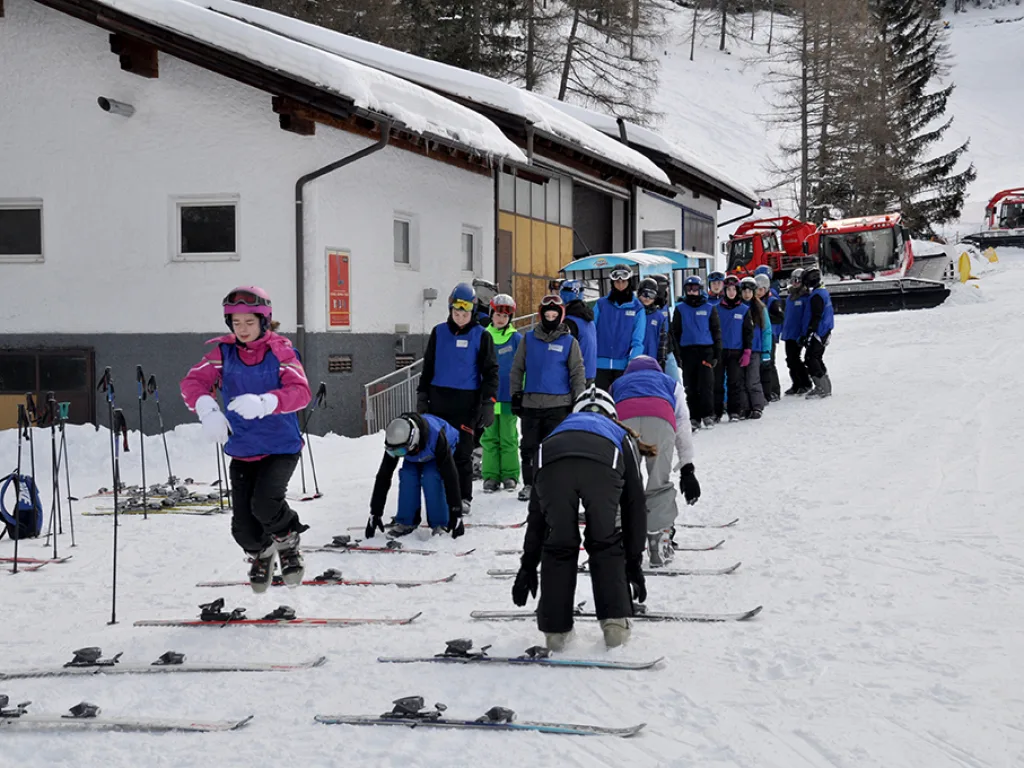 Gruppe rüstet sich vor einem Gebäude an der Talstation aus.